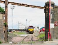 Having entered Leith Docks on 29 June 2005, EWS 66078 reverses its train over the dock exit road towards the coal terminal. Note the thick ropes in the foreground, normally jammed between the rails on the level crossing. This is to prevent the flangeways becoming blocked with mud and other debris, increasing the risk of a derailment.<br><br>[John Furnevel 29/06/2005]