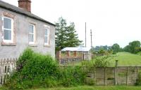 Looking east towards Kelso over the site of the level crossing and along the line of the platform at Maxton in June 2005. Note the white wicket gate allowing platform access still in place.<br><br>[John Furnevel 01/06/2005]