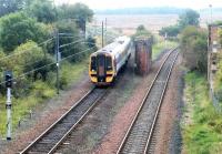 A Newcraighall - Dunblane train approaching Brunstane in October 2002 past the site of Niddrie North Junction and the remains of the bridge which once carried the high level Lothian Lines on their way to Portobello West and on to Leith docks. The single line 'sub' turns off to the right heading for Niddrie West. [See image 36752]<br><br>[John Furnevel 15/10/2002]