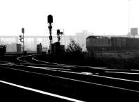 A type 2 emerges from the early morning mist as it leaves the north end of Millerhill yard with a mixed freight in August 1971. The train has just passed one of the yards long disused water towers as it takes the left fork at Niddrie South Junction and heads for the westbound <I>sub</I>.<br><br>[John Furnevel 21/08/1971]