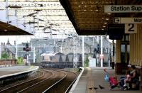 A family and 3 pigeons await the next train at Gilmour Street on a warm Saturday afternoon in July 2005, as a Hunterston - Longannet coal train rumbles through the adjacent platform.<br><br>[John Furnevel 30/07/2005]