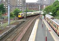 The west end of the busy Dalmuir station in July 2005, with a Balloch - Airdrie train approaching the station about to pass a recently terminated service from Motherwell standing in bay platform 5.<br><br>[John Furnevel 27/07/2005]