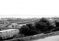 View over the yards and shed at Dundee West in May 1980. In the background a Type 2 is passing with a Glasgow Queen Street - Dundee train. On the right is the former steam shed, at this time in use as a DMU depot, finally closing in 1987.<br><br>[John Furnevel 26/05/1980]