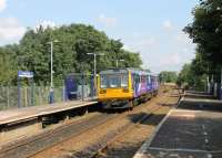 Trafford Park is now an unstaffed station with a basic two hourly service. 142011 hurries through without stopping on 20 August on its way from Lime St to Oxford Rd, now only seven minutes away. The huge industrial estate, which still has an operational internal railway, lies just beyond the trees.<br><br>[Mark Bartlett 20/08/2012]