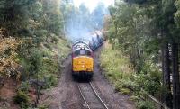 A southbound Railtrack PW/ballast Train seen shortly after passing through Aviemore station on 14 September 2004. The two EWS class 37 locomotives, led by 37406, are just starting to pick up speed and are about to pass below the road bridge carrying the B970.<br><br>[John Furnevel 14/09/2004]