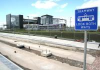 The new tram stop under construction at Edinburgh Park on 30 August 2012. In the background the 14.04 Edinburgh - Dunblane service calls at the station.<br><br>[John Furnevel 30/08/2012]