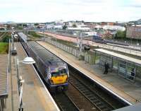 The 12.10 Helensburgh Central - Edinburgh Waverley pulls away from Edinburgh Park station on 30 August 2012. Running parallel with the E&G at this point is the trackbed of the York Place - Edinburgh Airport tram route, with platforms currently under construction on the right. Next stop east will be Haymarket for the train and (eventually) Bankhead for the tram.<br><br>[John Furnevel 30/08/2012]