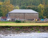 One of the most remarkable survivors from the heyday of the British railway branch line is the ubiquitous 'former goods shed'. Still seen throughout the country in various guises it appears almost indestructible (apart from the roof). This one was photographed in October 2005 looking south across the River Tweed towards the old goods yard at Walkerburn on the Peebles loop - nice roof!<br><br>[John Furnevel 07/10/2005]