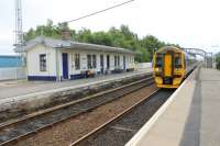 Thurso and Wick bound 158702 draws in to Dingwall station on its way north. The main station buildings are behind the camera with the smaller shelters seen here on the Inverness platform.<br><br>[Mark Bartlett 06/07/2012]