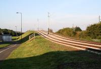 The Edinburgh tram route approaching Saughton, looking west in early morning sunshine on 23 September 2012. The line is rising here to cross the new bridge spanning Saughton Road, beyond which a tram stop will eventually be located. The catenary of the E&G can be seen on the right beyond the shrubbery.<br><br>[John Furnevel 23/09/2012]