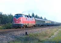 German Federal Railways 'Warship' (if I may be allowed the term) No. 220 037 speeds along at Leschede on the Rheine - Emden line in June 1976 with a northbound express. Surprisingly, only one coach of the train has been repainted in the then standard turquoise-beige livery, which had been introduced about two years previously.<br><br>[Bill Jamieson 05/06/1976]