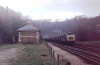 A Brush Class 47 leads a loaded MGR coal train for Buildwas down the gradient through closed Coalbrookdale station towards the bridge over the River Severn in 1982. The station had closed in 1962 but was later renovated and survives to this day.<br><br>[Mark Bartlett //1982]