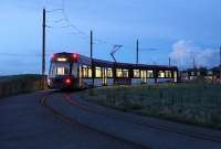 Dusk on a fine evening on the Lancashire coast as <I>Flexity</I> 011 waits on the Little Bispham turning circle before heading south for Starr Gate. During the illuminations season the half-hourly evening service to and from Fleetwood is supplemented by further trams turning back here to give a ten-minute frequency through the lights. <br><br>[Mark Bartlett 04/10/2012]