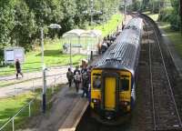 The 13.05 Paisley Canal - Glasgow Central calls at Corkerhill station on 28 September 2012. The majority of the large number of passengers waiting to board this service are students from the nearby Cardonald College. The electrified line on the right is the headshunt from Corkerhill depot located just beyond the curve in the background.<br><br>[John Furnevel 28/09/2012]