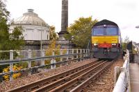 DRS 66305 passes the former Perth Water Works (now an art gallery) with the 4A13 Grangemouth - Aberdeen Intermodal train conveying both Asda and Tesco containers. The train has just passed the site of Perth's Princes Street station [see image 9931] and is about to cross the Tay Viaduct.<br><br>[Bill Roberton 14/10/2012]