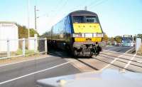 The 09.30 London Kings Cross - Edinburgh Waverley about to clear the level crossing at Warkworth, Northumberland, on 8 October 2012. Anybody who has ever had the slightest thought about attempting to jump the warning lights/barriers at a level crossing should stand here for a short time. Behind the DVT the former Warkworth station (closed in 1958) still survives as a private residence. The 472 bus is on its way from Amble to Alnwick. [See image 40762]. <br><br>[John Furnevel 08/10/2012]