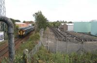 The 14.08 Glasgow Central - Paisley Canal service passing through the site of the original G&SWR Hawkhead station (1894-1966) [see image 20008] to reach the 1991 version located on the the other side of the bridge carrying Hawkhead Road. On the right are the out of use oil sidings previously used to supply aviation fuel via pipeline to Glasgow Airport. Taken on 28 September 2012 with preparatory work now underway for the forthcoming electrification of the branch.<br><br>[John Furnevel 28/09/2012]