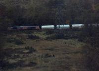 An unidentified railway enthusiast stands on a remote hillside in the pouring rain in order to photograph a passing freight train.<br><br>[Beth Crawford 27/10/2012]