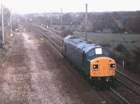 Ex-works 40141 runs north light engine on the West Coast Main Line in 1978. The shiny Class 40 is just approaching the start of the four track section at Balshaw Lane Junction while in the distance another member of the class heads south with a short train of 16T mineral wagons, heading for the Wigan area where coal for Lancashire power stations was still being produced at this time. This was probably the last major overhaul for 40141, which continued in service until withdrawn from Crewe in October 1983 followed by scrapping at Doncaster the following year.<br><br>[Mark Bartlett //1978]