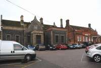 The approach to Thetford Sation, Norfolk, on the line from Ely to Norwich, on a damp October day in 2012. Two distinct station buildings: the original 1845 flint and stone structure on the left, long closed; the replacement brick building of 1889 on the right, open to a limited degree. Two trains per hour in each direction appear to use the station.<br><br>[Brian Taylor 18/10/2012]