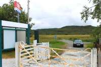 Duirinish station serves the village of the same name, but that's not immediately apparent. This is a view looking south from the station platform, through the entrance, with the narrow road to the village heading off across the moss.<br><br>[Mark Bartlett 10/07/2012]