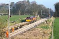 A Sunday WCML engineering possession for relaying sees DBS 66213 and some flat wagons standing alongside brand new track at Woodacre near Garstang in March 2012. A plant machine is just visible inside the cutting on the new Up line.<br><br>[Mark Bartlett 25/03/2012]