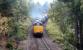 A southbound Railtrack PW/ballast Train seen shortly after passing through Aviemore station on 14 September 2004. The two EWS class 37 locomotives, led by 37406, are just starting to pick up speed and are about to pass below the road bridge carrying the B970.<br><br>[John Furnevel 14/09/2004]