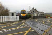 Just to the south of Staveley station is this well known level crossing. In earlier times the line was double track, the crossing manually controlled and the road was the main route from Kendal to Windermere. With the line singled, the crossing automated and the village bypassed the scene has changed but the railway cottage is still occupied as 185105 passes on its way to Oxenholme and Manchester Airport on a murky November afternoon.<br><br>[Mark Bartlett 16/11/2012]