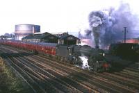 Shortly after leaving Stirling station in 1965, Black 5 no 45214 takes a train for Glasgow Buchanan Street past Stirling South shed (63B). An NBL Type 2 diesel can just be made out in the siding on the right. <br><br>[Robin Barbour Collection (Courtesy Bruce McCartney) //1965]