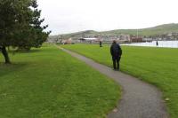 At the foot of the bank in Campbeltown the C&MLR trains emerged from the cutting onto the foreshore and turned left towards the harbour. [See image 37847]. This tarmac footpath follows the line of the narrow gauge track across the green but, as with the other surviving bits of the railway, no mention is made of its origins and why the path follows the route that it does. An information board in this area would be very useful for the uninitiated. <br><br>[Mark Bartlett 13/10/2012]