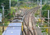 Looking north from the A6071 road bridge at Gretna on 3 August 2007, with the modern day overhead mish-mash of steel and spaghetti doing its best to prevent a half decent photograph [see image 41108]. The train is the morning Basford Hall - Coatbridge containers with the usual pair of Freightliner class 86 locomotives in charge. The train is about to cross the border over the River Sark and take the Beattock route north at the junction.<br><br>[John Furnevel 03/08/2007]