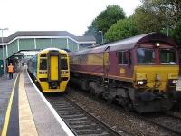 Newly refurbished 158818 waits for 66089 to power past rather smokily on a loaded steel working before it can get right of way to cross the up line to access the Maesteg branch with the 10.46 departure from Bridgend station.    <br>
<br>
 <br>
<br>
<br>
<br><br>[David Pesterfield 31/10/2012]