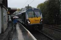 An eastbound service for Airdrie pauses at Hyndland in inclement weather. The new footbridge and lifst under construction at the north or west end of the station can be seen in the background. A new platform will be built to the right.<br><br>[Ewan Crawford 14/11/2012]