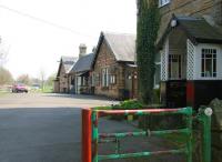 Looking over the pedestrian section of the old entrance gate giving access to the station forecourt at Middleton-in-Teesdale in May 2006. The porch of the former Station Master's house is on the right with the main building beyond. The station saw its last passengers in November 1964 and the site is now a large caravan park. [See image 9313]<br><br>[John Furnevel 08/05/2006]