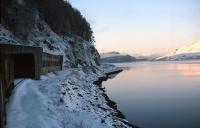 A Class 26 with a train for Kyle noses into the Loch Carron avalanche shelter on a crisp winter's morning in early 1977.<br><br>[Frank Spaven Collection (Courtesy David Spaven) //1977]