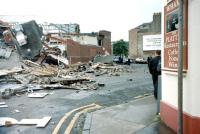 View from the north end of Crawford Street, Largs, following the unscheduled demolition of part of the station by the 06.15 from Glasgow Central on 11 July 1995 [see image 19774]. The western section of the building along the side of what was platform 4 (latterly platform 2) is clearly shown. To the right was a small car park. The glazed roof, which rested on that part of the building, is precariously balanced. All was swept away in the subsequent demolition.<br><br>[Colin Miller 11/07/1995]