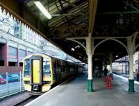 Welcome to the Dark Side. Work on refurbishment of the 'sub' got underway at Waverley in late 2012. The island platform, which stands outside the south wall of the main station building, is seen here in June 2002 with a Newcraighall - Dunblane service having recently arrived at platform 21. The old canopy looks a little the worse for wear, as does the station entrance on Market Street in the background (also included in the refurbishment programme).<br><br>[John Furnevel 04/06/2002]