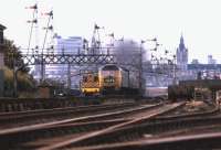 With an exhaust plume and the Aberdeen skyline above it, a Class 47 lifts an east coast service out of the city in July 1974 and is about to pass Ferryhill signal box.<br><br>[John McIntyre /07/1974]