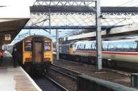 47413 draws 91004 and train into platform 1 for Kings Cross after hauling the set from Leeds via Normanton during isolation of overhead supply on the direct route in November 1990. On the left is 150234 with a local service to Leeds, awaiting access to the single line branch to Wakefield Kirkgate.<br><br>[David Pesterfield 03/11/1990]