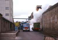 Side by side at Balmenach Distillery in October 1966, one mode of transport soon to be extinguished by the other. Balmenach was the most southerly of two Speyside distilleries with its own 'pug' locomotive, in this case shunting inbound barley and outbound spirit over a short private branch line to exchange sidings at Cromdale station on the Speyside line. [See image 24574] <br><br>[Frank Spaven Collection (Courtesy David Spaven) /10/1966]