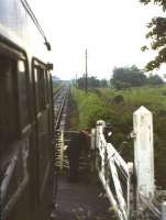 Not an aid to fast rail journeys - the guard of the 3.5pm Stirling-Kinross-Perth 'Devon Valley' train deals with the level crossing gates at Rumbling Bridge shortly before the 15th June 1964 withdrawal of passenger services between Alloa and Kinross.<br><br>[Frank Spaven Collection (Courtesy David Spaven) /06/1964]