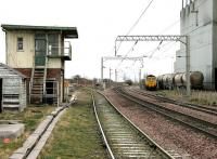 Looking south along a ghostly ECML at Owellmains on Boxing Day 2004. The LaFarge cement works on the right is shut down for the holiday period with a Freightliner class 66 stabled in the exchange sidings. The line on the left runs to the landfill site, destination of the 'Binliner' trains from Powderhall [see image 4773].<br><br>[John Furnevel 26/12/2004]