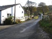 View south of the Hillside Lane Level Crossing, Millhouse Green, west of Penistone on the former Manchester to Wath 1500V DC electrified line in 2012. Note the north side gate post and crossing gate still in situ with a much extended 'Keepers Cottage' on the left. <br><br>[David Pesterfield 11/11/2012]