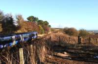 A Down ScotRail service passes the spectacularly sited but long gone station at Lunan Bay in January 2013. The Station House remains, but is hidden by the trees.<br><br>[Brian Taylor 30/01/2013]