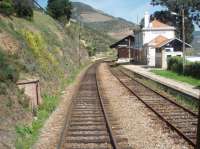 Most Douro Valley trains pass through the wayside station of Covelinhas without stopping and this picture was taken through the rear corridor connection window of a Pocinho to Porto fast train. Only one platform now in use as the line in front of the main building and goods shed is disused but, as seems to be the case with most CP stations, there is still a small but very clean toilet block available to the public. <br><br>[Mark Bartlett 20/03/2008]