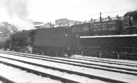 An unidentified WD Austerity 2-8-0 takes a freight west along the southern perimeter of Gateshead shed towards King Edward Bridge Junction in the 1960s. The train is about to pass D5106 standing in the high level Chaytor's Bank sidings. The Type 2 diesel had arrived here new from Darlington Works in September 1960. <br><br>[K A Gray //]