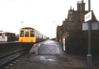 A cold and wet January day at Saxilby, Lincolnshire, looking north towards Gainsborough in 1988. A 4-car DMU for Lincoln is about to depart southbound, while a chilly looking group of passengers huddles under the shelter on the down platform.<br><br>[Ian Dinmore /01/1988]