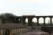 A class 141 Pacer in West Yorkshire PTE red livery runs across the lofty Denby Dale viaduct in February 1991, before entering the station out of view on the left. <br><br>[David Pesterfield 09/02/1991]