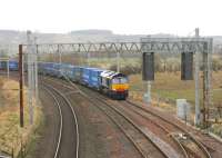 DRS 66305 waits with a long container train in the Up Loop at Clifton and Lowther for southbound WCML passenger services to overtake. The second line of trees above the train mark the course of the Stainmore line to Appleby (East) which diverged from the WCML just north of this point. The Down Line equivalent loop to this one is situated in Penrith itself [See image 41209]<br><br>[Mark Bartlett 04/02/2013]