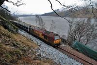 67004, still in EWS livery, passes GBRf 66734 'The Eco Express' in its green shroud. The class 66 is to be cut up on site. What must pass through other driver's minds passing this location?<br><br>[Ewan Crawford 12/02/2013]